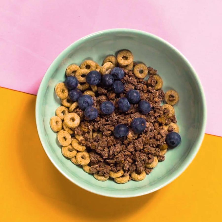 a bowl full of cereals and some fruits