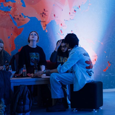 a group of young people sitting in a blue-lighted area