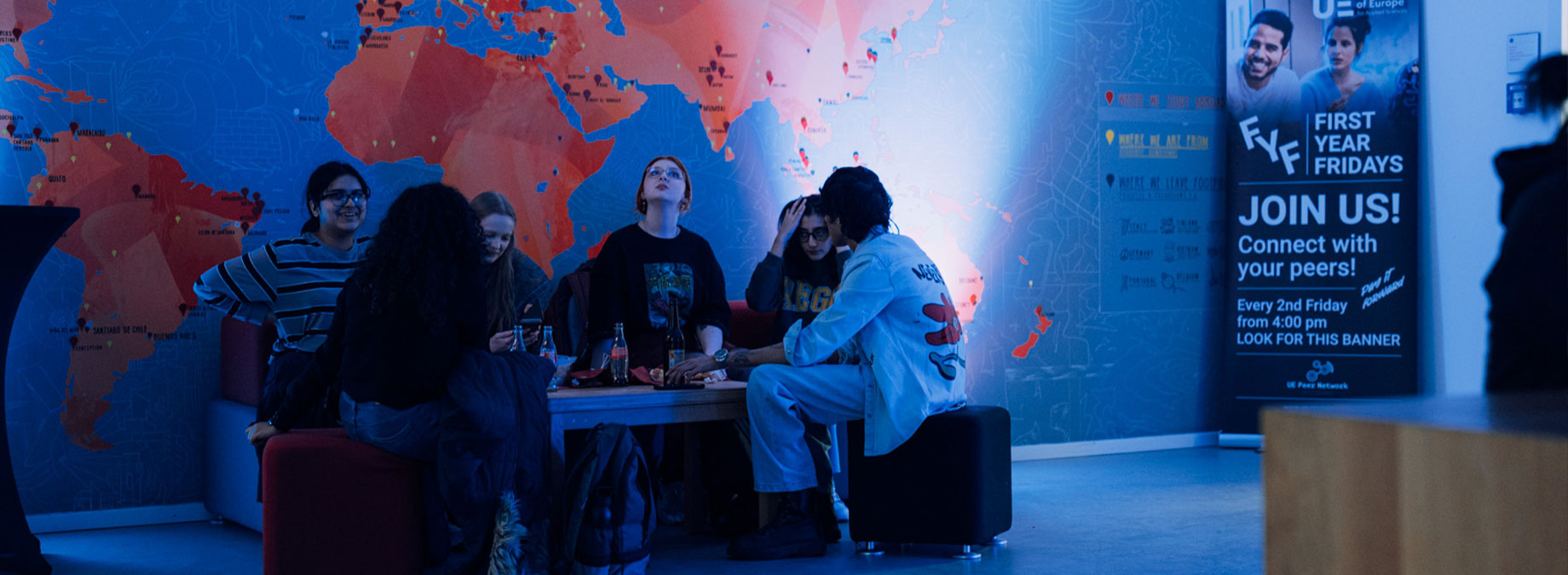 a group of young people sitting in a blue-lighted area