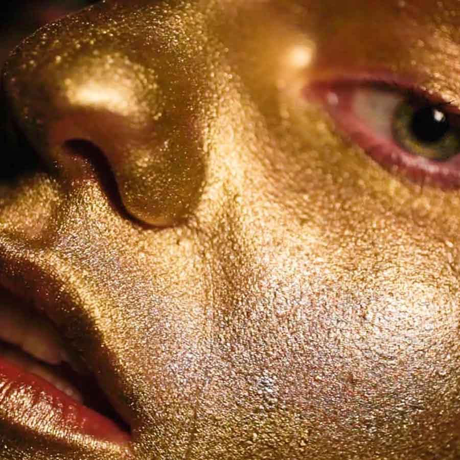 a detail photo of a human face covered in gold