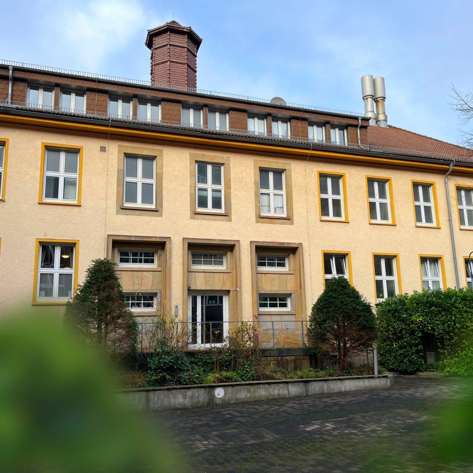 a large building with a pond in front of it