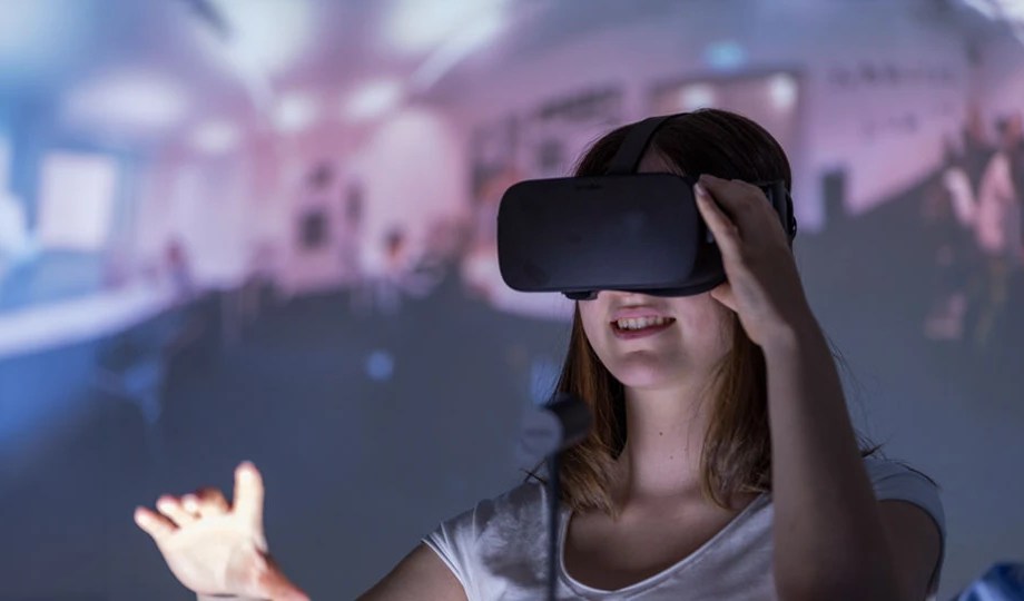 a girl is standing in a digital classroom wearing vr glasses