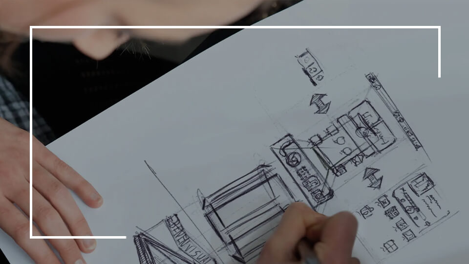 A student drawing a design for her MA Design Leadership program