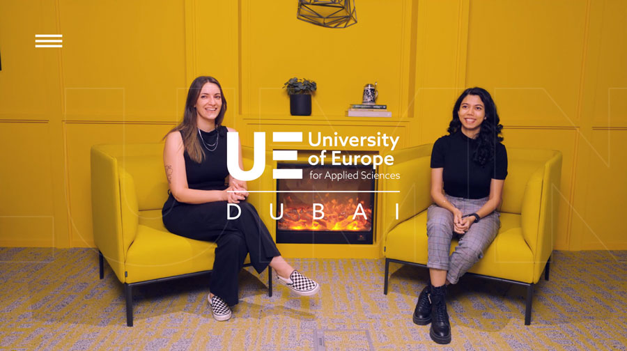 two women smiling and sitting on yellow sofas