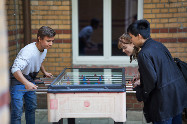 three people playing table soccer