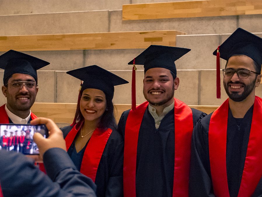 Four graduates pose for a photo