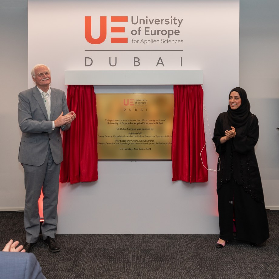 One man and two women unveil plaque on a wall