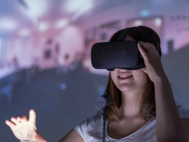 a girl is standing in a digital classroom wearing vr glasses