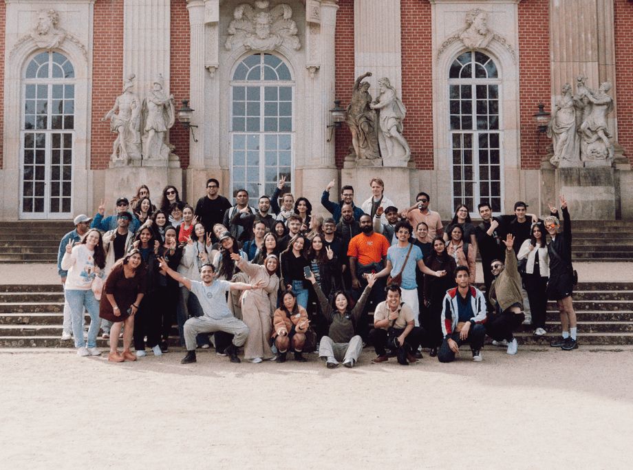 a group of people posing for a photo in front of a building