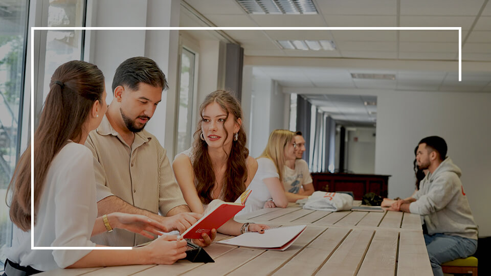 a group of people sitting at a table looking at papers