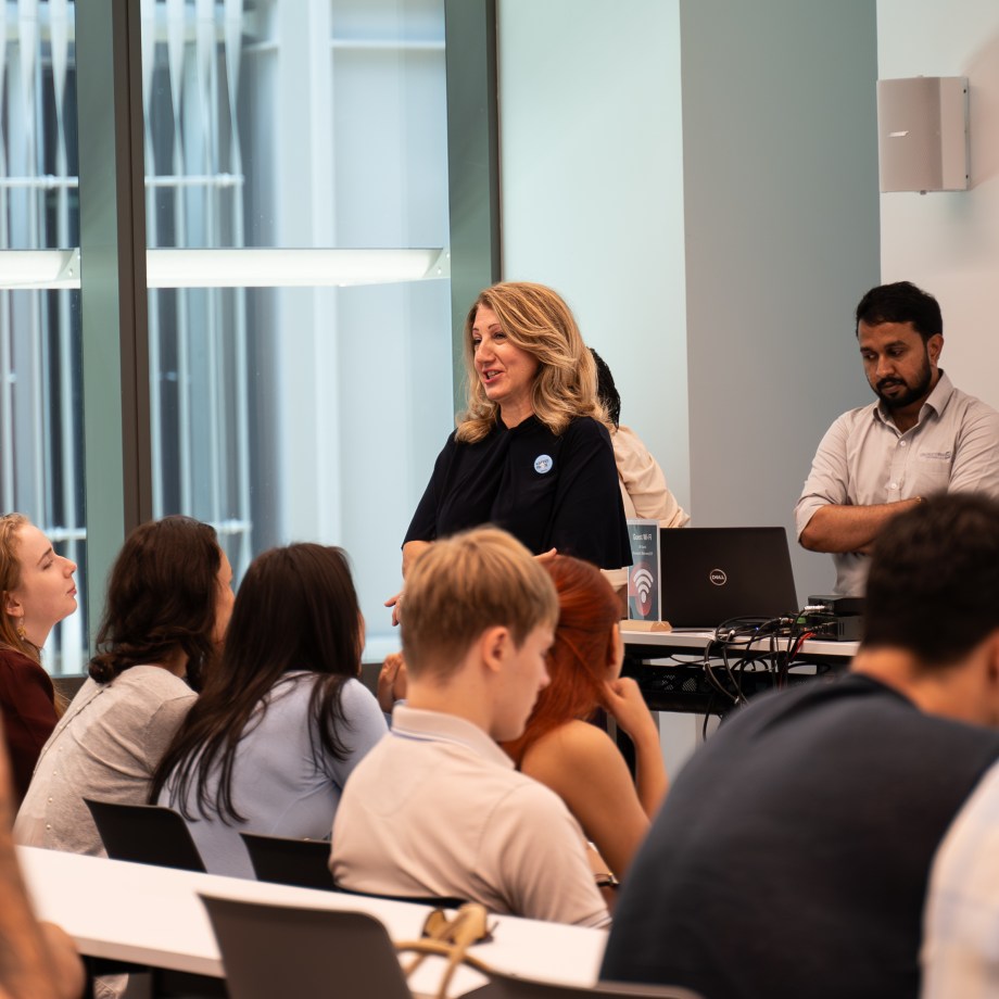 a person talking to a group of people in a room