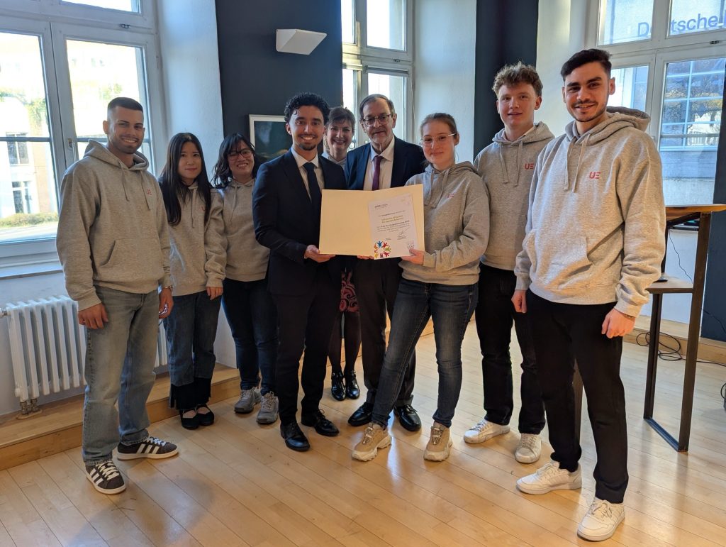 eine Gruppe von Personen, die für ein Foto mit einer Urkunde posieren