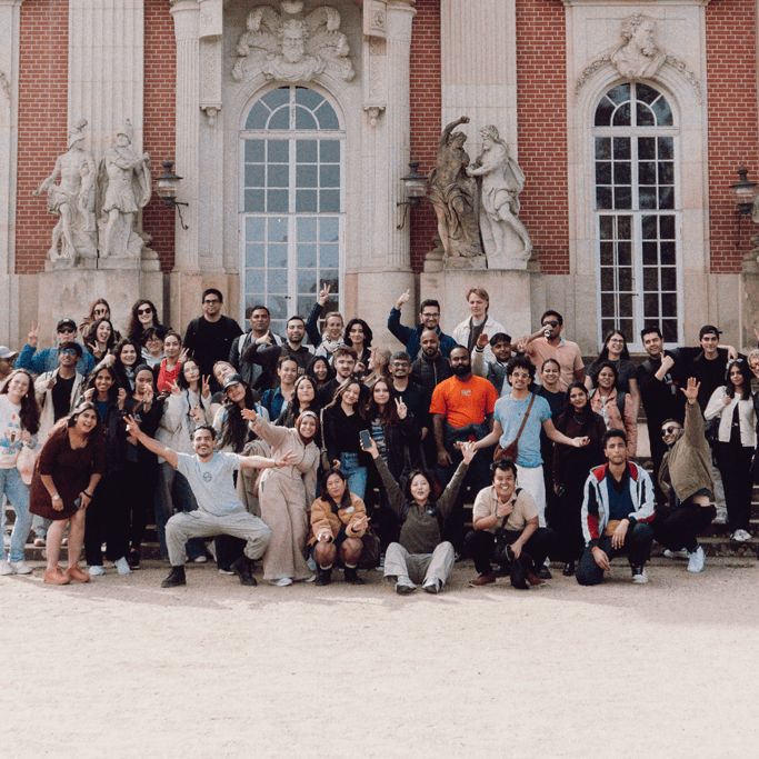 eine Gruppe von Menschen, die für ein Foto vor einem Gebäude posieren