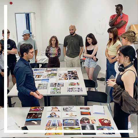 a group of people standing around a table with books on it
