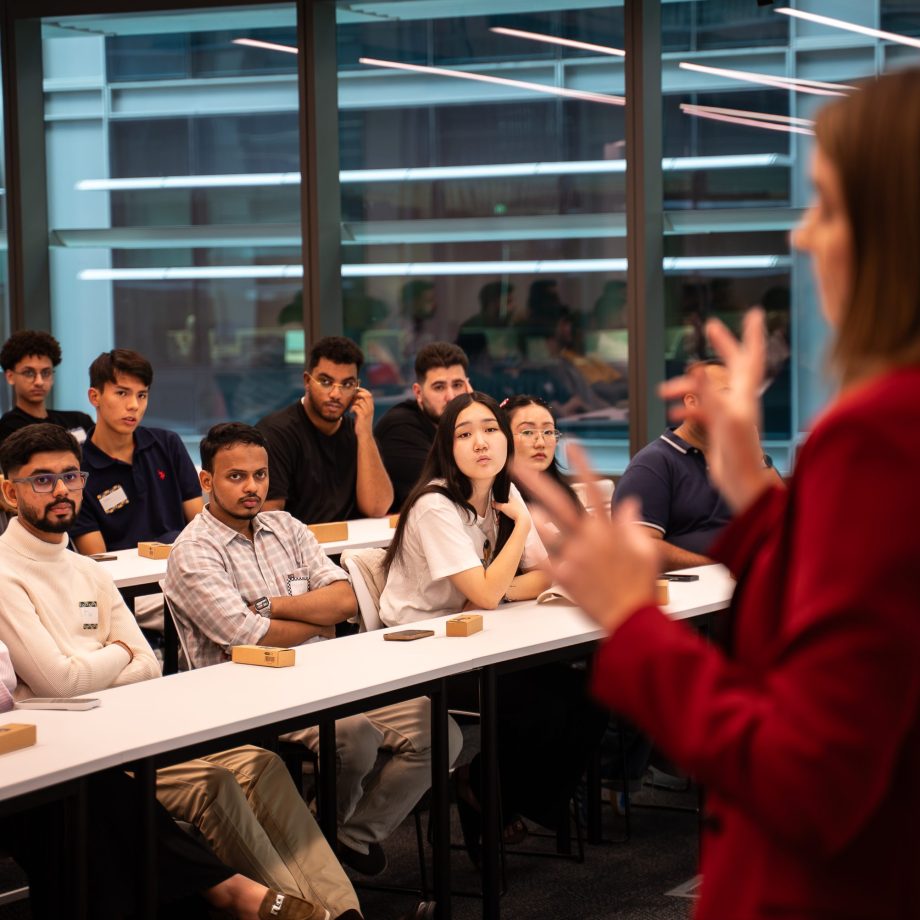 a person taking a picture of a group of people sitting at a table