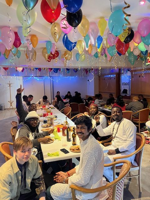 a group of people sitting at a table with balloons