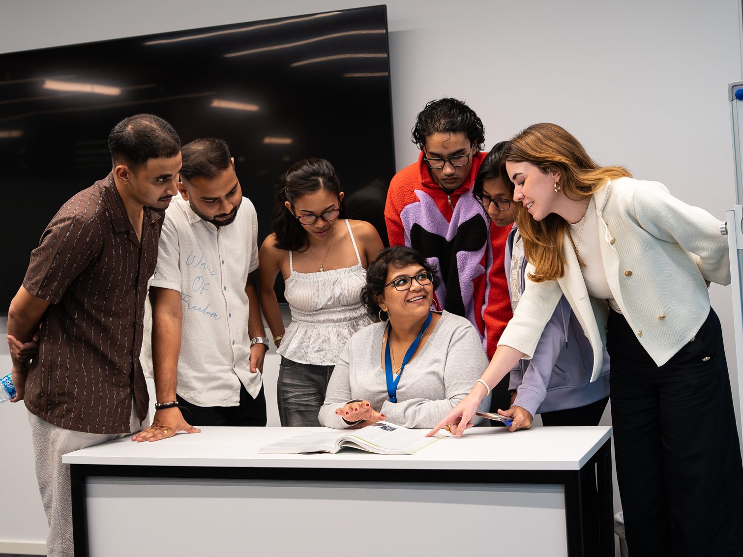 a group of people looking at a paper